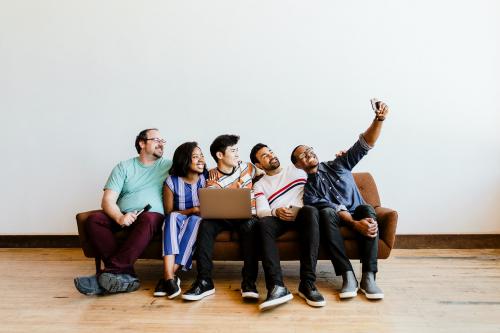 Group of diverse friends taking a selfie on a couch - 2052694