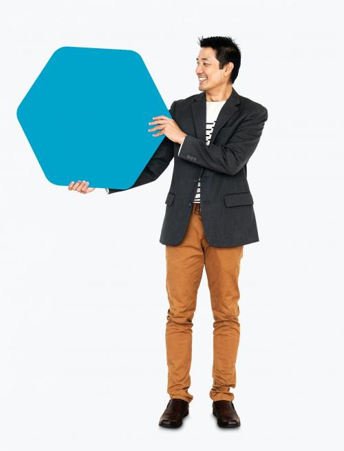 Cheerful man showing a blank blue hexagon shaped board - 491073