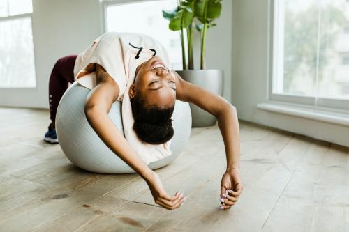 Black woman doing stretching on a balance ball - 2194664