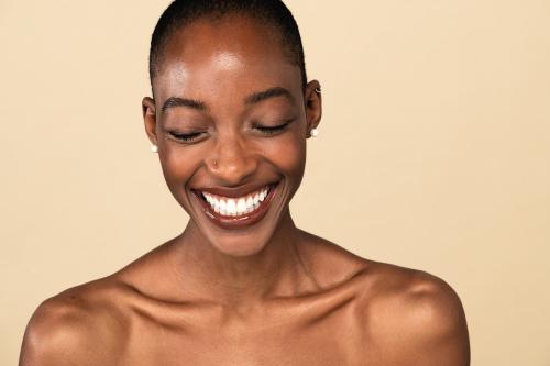 Happy nude black woman against a beige background - 2254269