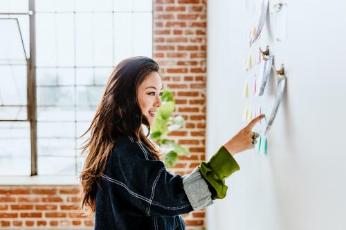 Creative woman with business plans on the wall - 2030341