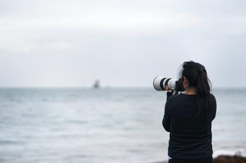 Female photographer capturing Seymour Tower, Channel Islands - 2042601