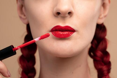 Closeup on beautiful woman applying a red lipstick - 2054016
