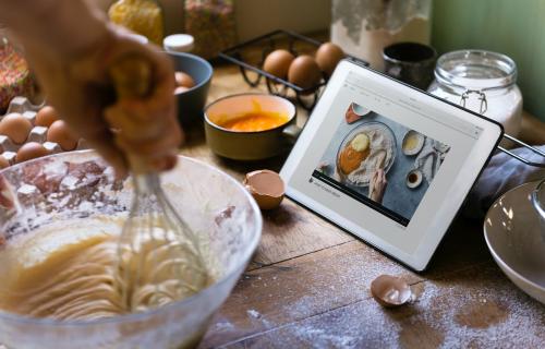 Woman whisking while looking at a recipe on a tablet - 484681