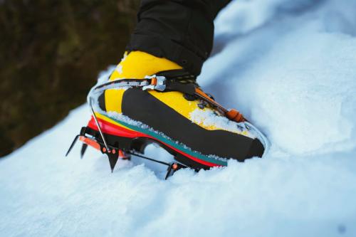 Man climbing a snowy mountain with crampons - 2097746