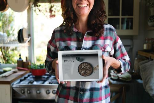 Happy woman holding a screen with a baking recipe - 485684