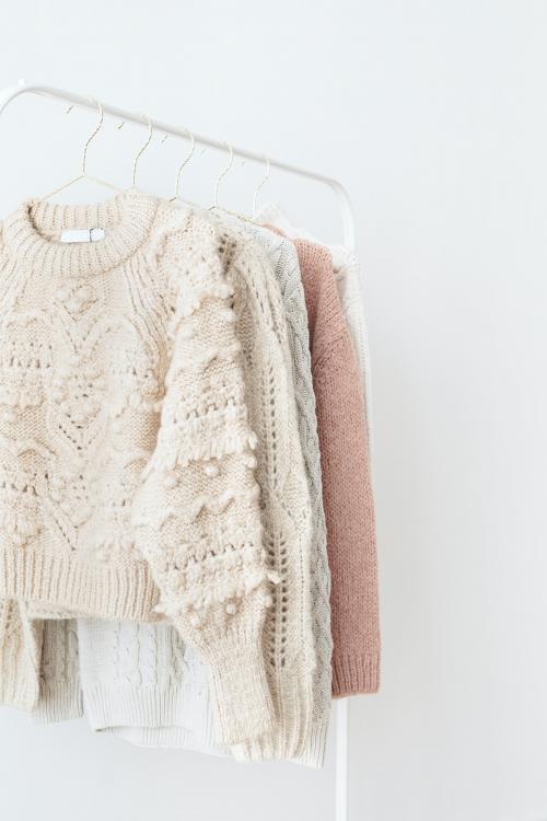 Casual knitted sweaters hanging on a rack - 2254079