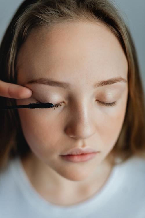 Beauty blogger applying mascara to her model - 1232036