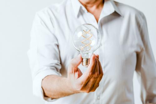 Creative man holding a light bulb - 1233763