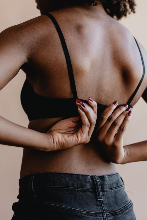Black woman unhooking her bra - 1219051