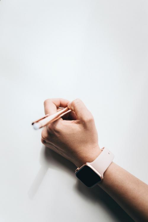 woman wearing a smartwatch writing on a paper - 1226522