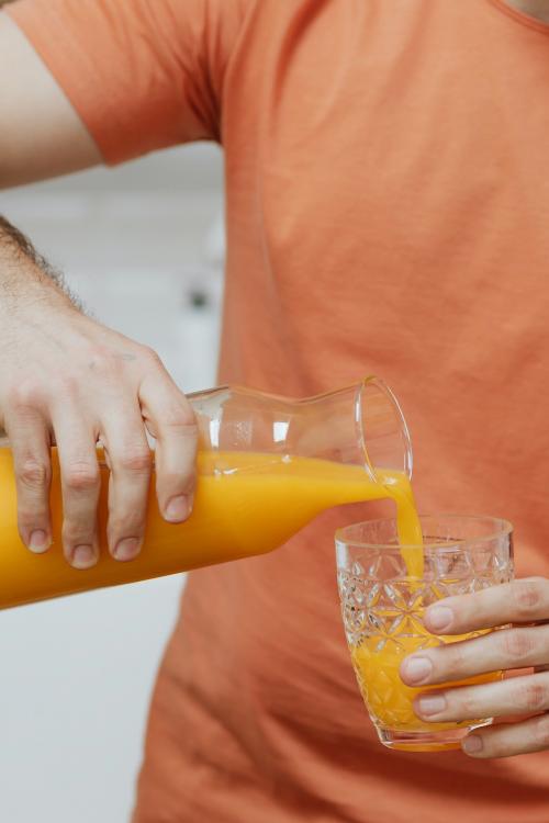 Man pouring orange juice into a glass - 937500