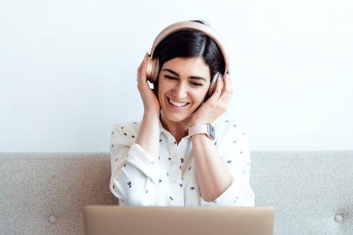Happy woman with headphones on the couch - 1226518