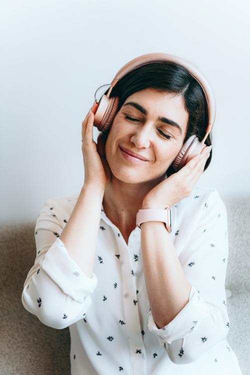 Happy woman with headphones on the couch - 1226520