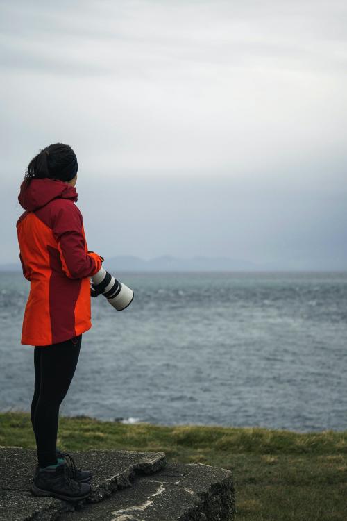 Female photographer at Vaternish Lighthouse on Isle of Skye, Scotland - 1233367