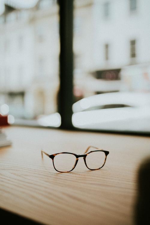 Pair of glasses on a wooden table - 598332