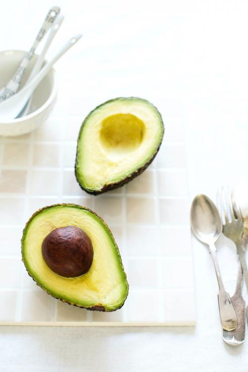 Sliced organic avocado on the kitchen table - 893654