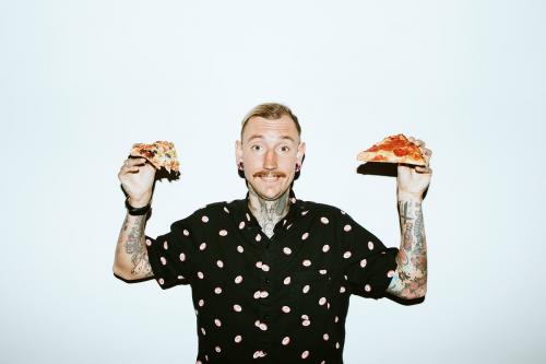 Tattooed man holding a pizza in his hands - 1225202