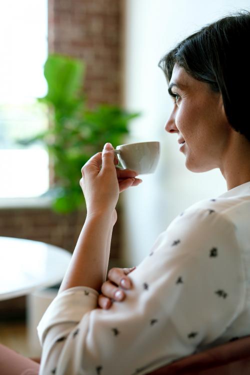 Woman sipping coffee at a cafe - 1226456