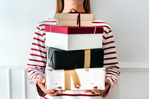 Woman carrying a stack of presents - 1231776
