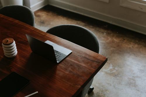 Digital tablet and a laptop on a wooden table in a meeting room - 1216756