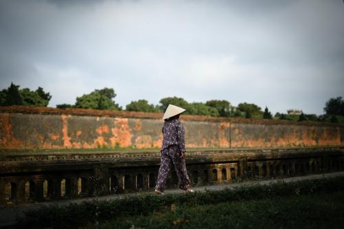 Vietnamese woman in a traditional costume walking on a pathway - 843908