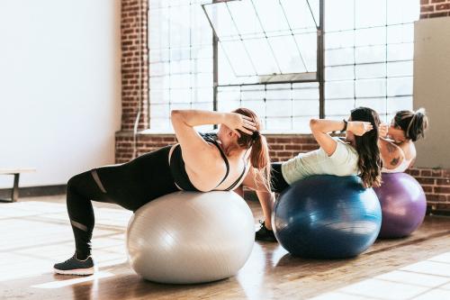 Healthy women using fitness ball for an ab workout - 1225146