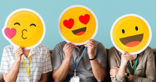 Cheerful people holding emoticon icon - 414640