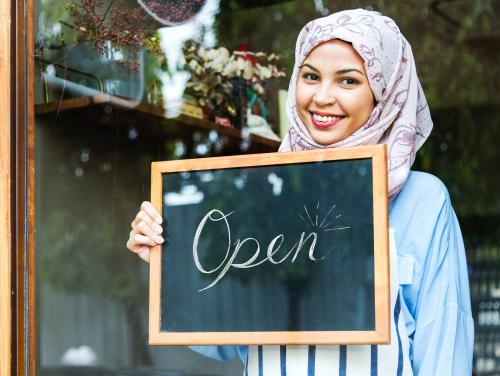 Islamic woman small business owner holding blackboard with smiling - 400091