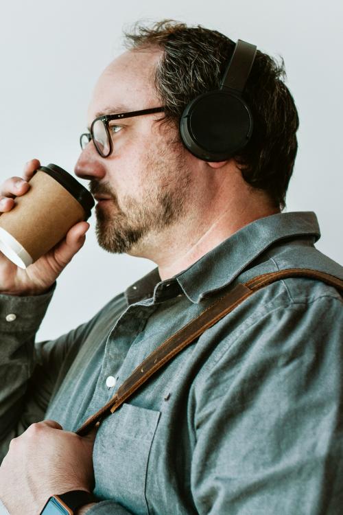 Man drinking a hot coffee while listening to music - 1226684