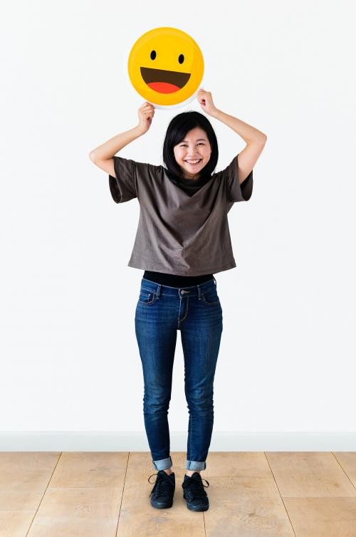 Cheerful woman holding emoticon icon - 414529