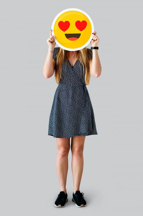 Cheerful woman holding emoticon icon - 414545