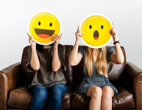 Cheerful people holding emoticon icon - 414582