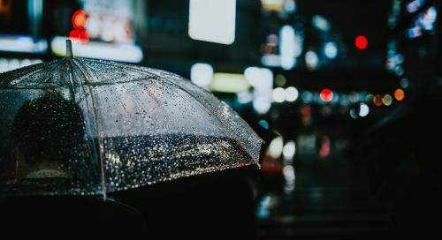 Man walking with a transparent umbrella in a city at night - 935476