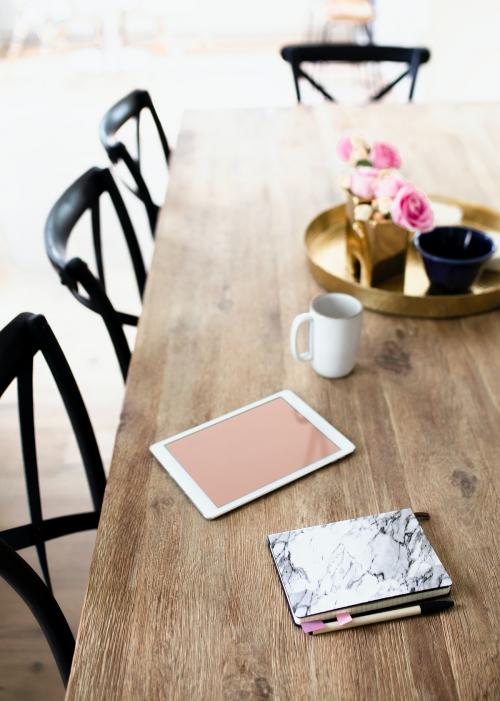 Digital tablet and a marble texture notebook on a wooden dining table - 1211281
