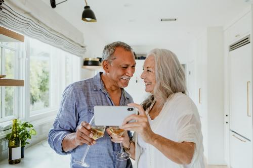 Elderly couple taking a selfie while having a wine - 1211868