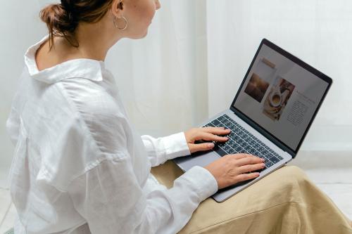 Woman using a laptop on a bean bag - 1212721
