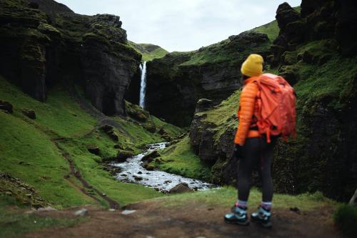 Female hiker with a view of Kvernufoss waterfall in South Iceland - 1206156