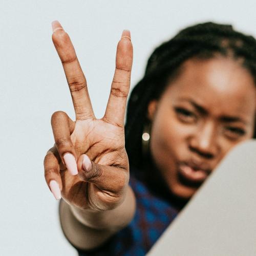 Black woman showing a v sign - 1208305