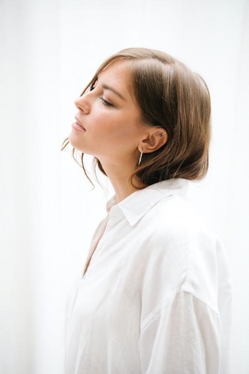 Side view of a brown hair woman in a white shirt - 1212525