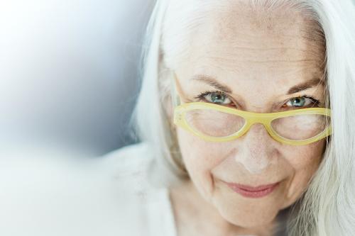 Portrait of an elderly woman with a yellow eyeglasses - 1211892