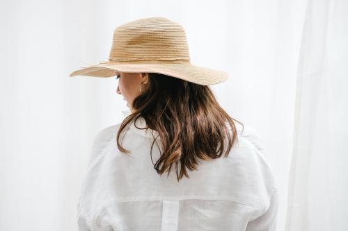 Rearview of a brown hair woman in a woven hat - 1212554