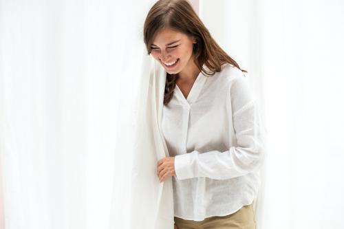 Smiling woman by the white curtain - 1212679