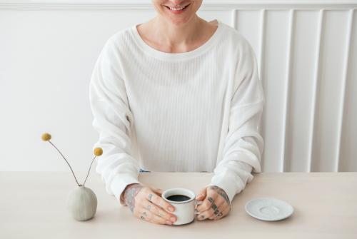 Smiling tattooed woman having a coffee - 1212719