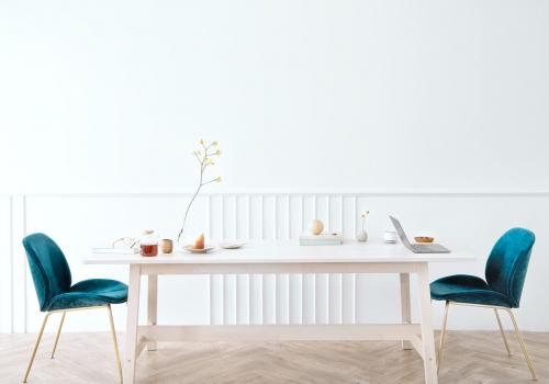 Wooden table with blue velvet chairs in a white room - 1215223