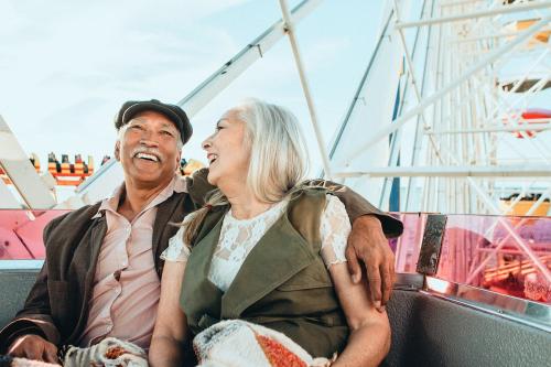 Cheerful senior couple enjoying a Ferris wheel by the Santa Monica pier - 1202658