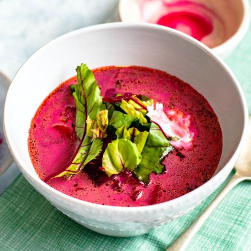 A bowl of healthy beetroot leaf soup with cream on a table - 1204787