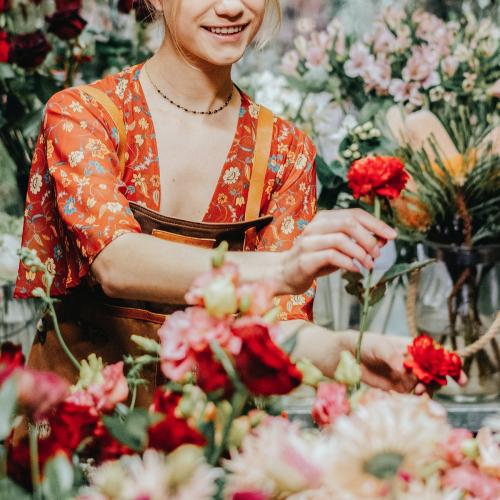 Florist arranging Paeonia peter brand in her shop - 1207153
