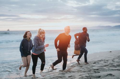 Cheerful friends running on the beach - 1079783