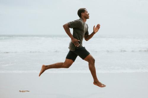 Black man running on the beach - 1079784